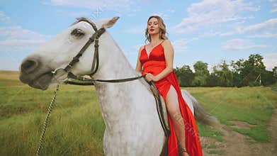 Portrait woman sitting on horseback hand stroking white fur mane. girl with horse animal pet walking, green grass field