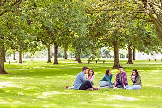 College students sitting on grass in park