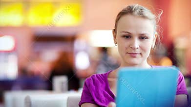 Woman in cafe using her touchpad