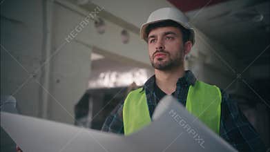 Caucasian builder man handyman guy foreman holding blueprint architect male inspecting building electrician employee