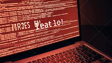 A close-up of a laptop screen glowing red with lines of corrupted code and a large warning danger message indicating a