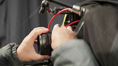 Man videographer adjusts camera lens before recording