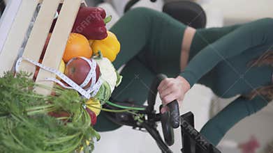 A woman rides an exercise bike, promoting wellness and balance
