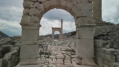 Fast drone retreat through Roman arch in Sagalassos, Turkiye
