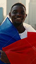 Portrait of African American man putting French flag on shoulders
