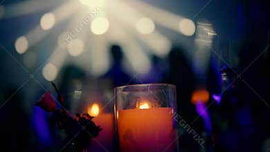 Evening celebration with candle decor and dancing silhouettes in banquet hall.