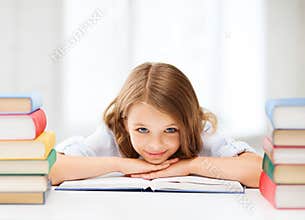 Pretty girl with many books at school