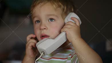 Excited little boy talking over telephone receiver
