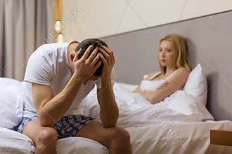 Man sitting on the bed with woman on the back