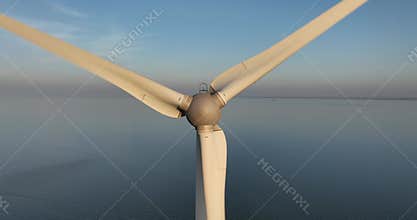 wind turbine at sunset, golden hour aerial drone view.