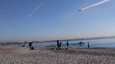 The F16 fighter performs aerobatics over the sea against the background of mountains