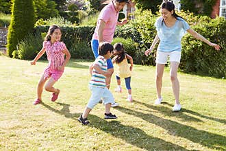 Asian Family Playing In Summer Garden Together