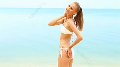 Happy smiling woman in bikini at the beach