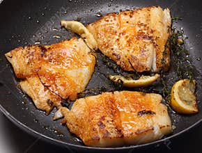Fish cooking in frying pan