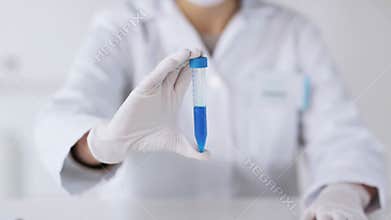 Close up of scientist with full beaker in lab