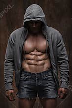 Young muscular man with open jacket revealing muscular chest and abs
