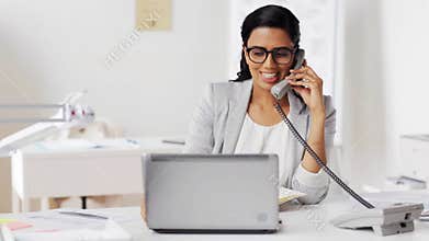 Businesswoman calling on phone at office
