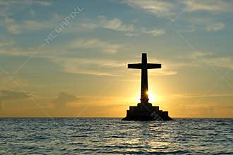 Tropical sunset with cross silhouette.