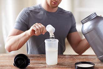 Close up of man with protein shake bottle and jar