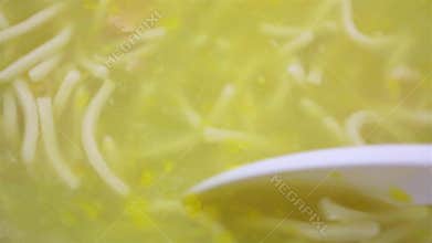 Stirring chicken noodle soup