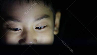 Close up Asian cute boy watching on laptop computer.