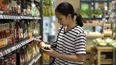 Asian girl, woman walking, looking and shopping for sauce in supermarket isle