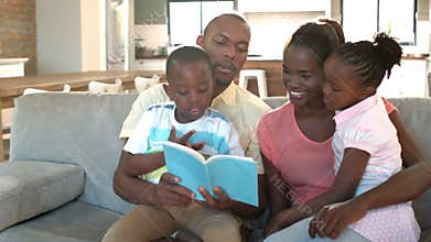 Parents and children sitting on couch reading