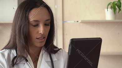Professional female work as physician chatting via internet.
