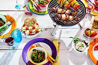 Overhead Well Laid summer table with colorful dish and brazier
