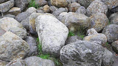 Group of big boulder stones lying in field, natural geologic background