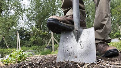 Man digging the earth with a garden spade