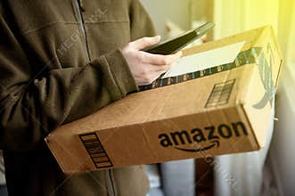 UPS parcel delivery woman scanning parcel from Amazon online retailer