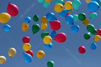 Multi-coloured balloons depart to the sky