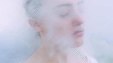 Close up view of a womanâ€™s face being steamed by a professional cosmetology steamer. Womanâ€™s face in a dense steam
