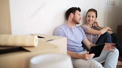 Happy couple with tablet pc at new home