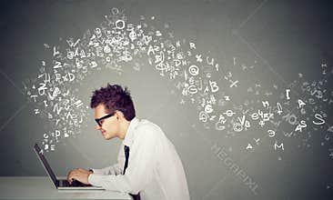 Young man typing on laptop computer alphabet letters flying away