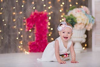 Cute baby girl 1-2 year old sitting on floor with pink balloons in room over white. Isolated. Birthday party. Celebration. Happy b
