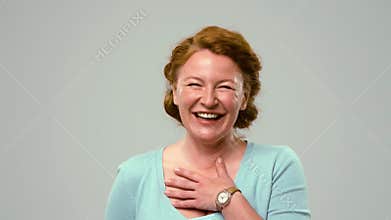 Actress of mid age sincerely laughing.