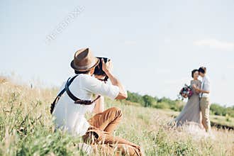 Wedding photographer takes pictures of bride and groom in nature, fine art photo