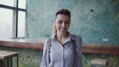 Portrait of young beautiful caucasian woman in modern coworking space. Businesswoman looking at camera, smiling,
