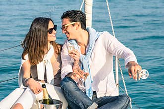 Young couple in love on sail boat with champagne flute