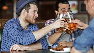 Happy male friends drinking beer at bar or pub