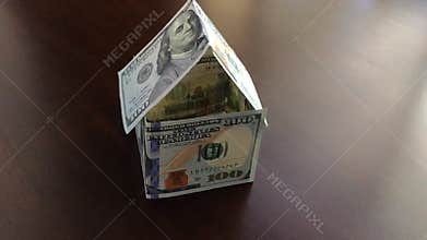 Slow Motion Panning of Paper Money House Blowing Away