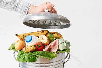 Hand Putting Lid On Garbage Can Full Of Waste Food