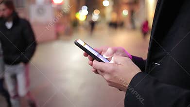 Man Standing In A City Street And Texting Fast On Smart Phone