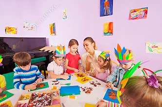Teacher helps kids glue craft images