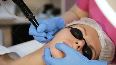 Therapist beautician makes a laser rejuvenation