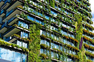 Green skyscraper building with plants on the facade