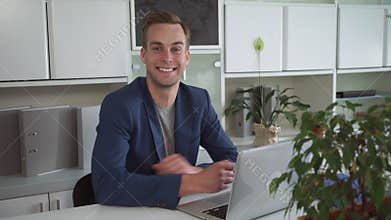 Happy businessman working on the laptop in the modern office.