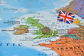 UK flag and coin on map, political or financial crisis concept